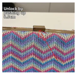 Detailed view of the gold push-lock buckle on a multicolor tweed woven evening handbag