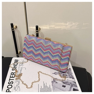 Macro detail of multicolored woven bag with wavy pattern and gold metal clasp closure