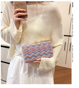 Detail of colorful zigzag weave texture and gold chain on rectangular evening bag