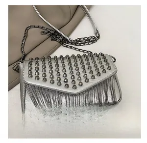 Detailansicht der silbernen Metallic-Tasche mit Kegelnieten und Metallkettenquasten