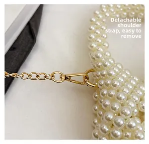 Detail of detachable gold chain strap with lobster clasp on handmade pearl beaded bag