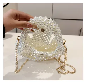 Detail of the white pearl beaded handbag interior showing simple inner space and gold chain