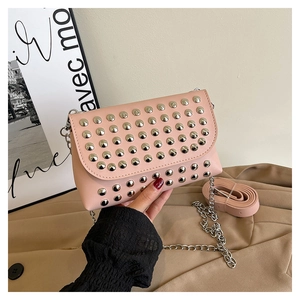 Detailed shot of pink crossbody bag featuring silver studs and adjustable shoulder strap