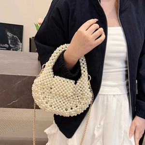 Handmade pearl crescent handbag with a gold chain strap shown on a marble surface