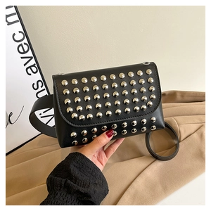 Close-up of black leather shoulder bag with rows of polished silver metal studs