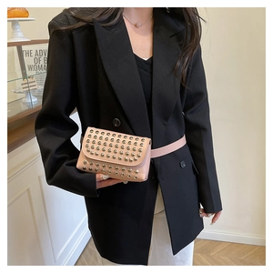 Pink leather fanny pack with gold studs styled on a black double-breasted blazer