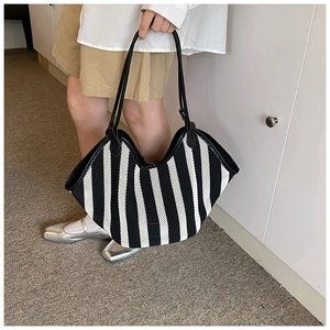 Large woven tote bag with black and white vertical stripes and long leather handles