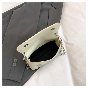 Detailed view of the beige crossbody bag interior with silver magnetic buckles and black lining