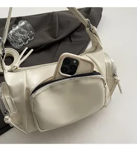 Detail showing a white vintage biker bag with front pocket holding a smartphone