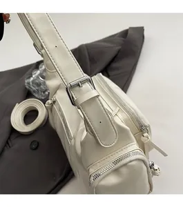 Detail of white vintage motorcycle bag with adjustable strap and silver metal hardware