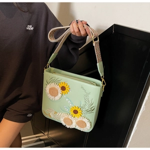Detail of mint green crossbody bag with sunflower embroidery and jacquard strap