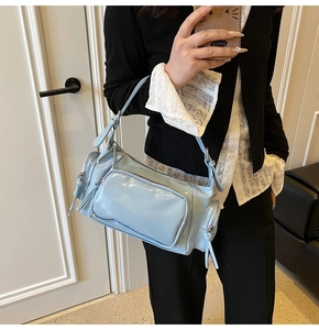 Close-up of light blue shiny multi-pocket biker bag showing texture and size