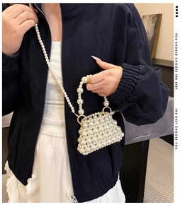 Detail of handmade beaded pearl crossbody bag with golden rings and crossbody strap