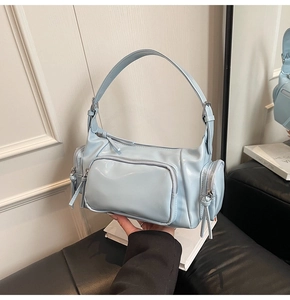 Detailed view of light blue retro motorcycle bag with multiple functional zippers
