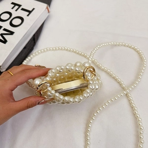 Detail of handmade pearl beaded mini bag with gold rings and cosmetic storage capacity