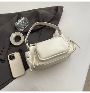 Detail of off-white retro motorcycle bag with multi-pocket design on a suit background