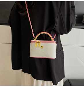 Detail of mini box bag showing contrast trim, gold handle and 3D floral accent
