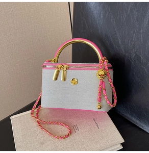 Quilted vanity bag detail with neon pink trim and elegant golden camellia hardware