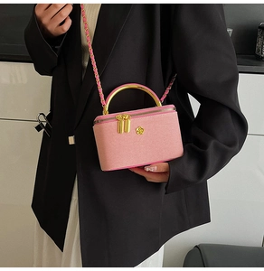 Detailed close-up of a pink woven mini bag with golden metal handle and chain strap