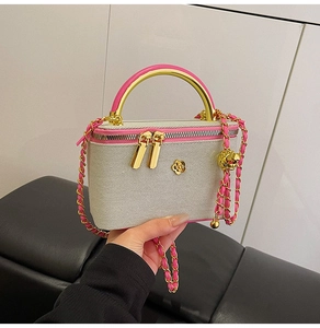 Detail view of mini quilted bag featuring golden camellia charm and pink leather handles