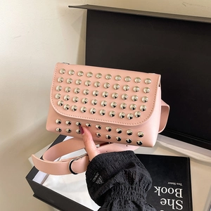 Pink punk style crossbody bag with silver studs and wide strap shown with a gift box