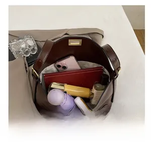 Internal capacity view of dark brown tote bag with umbrella, wallet, and cosmetics