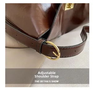 Macro shot of adjustable leather shoulder strap with golden metal buckle on tote bag