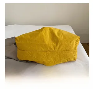 Close-up of the durable wear-resistant bottom design on yellow canvas tote bag