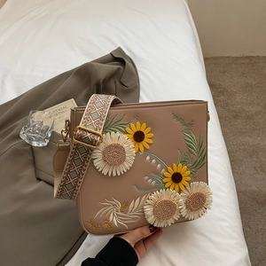 Brown leather crossbody bag with sunflower embroidery and a wide geometric strap