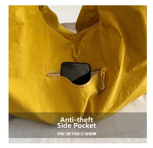 Detail of a yellow tote bag featuring a functional anti-theft side zipper pocket for smartphones