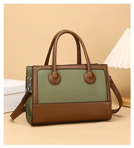 Detail der grün-braunen Kontrast-Ledertasche mit silbernen Metallbeschlägen und Clips