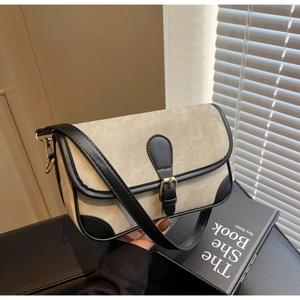 Detailed view of vintage fabric shoulder bag with contrast leather trim and buckle flap