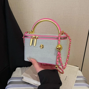 Chic quilted denim vanity case with pink trim, gold camellia detail and chain strap