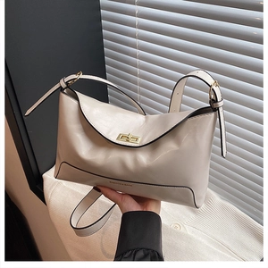 Detail of cream leather tote bag featuring gold twist lock and FASHION & BAGS lettering