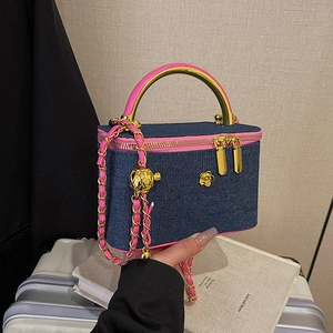 Navy denim vanity bag with pink leather trim, gold camellia and metal chain handle