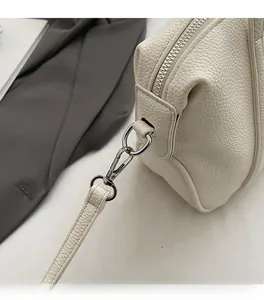 Close-up of premium silver zipper and hooks on creamy lychee grain leather tote bag