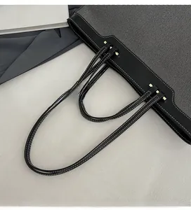 Detail of contrast stitch on gray and black tote bag with double shoulder straps