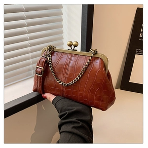 Close-up of vintage brown shell bag with crocodile texture and antique metal clasp