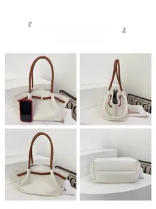 Detailansicht der weißen Tasche mit Litschi-Muster, braunen Griffen und Metallschnallen