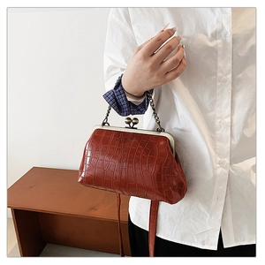 Detail of dark brown stone pattern shell bag with vintage metal kiss lock and chain handle