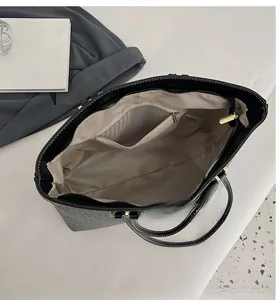 Detail view of denim tote bag interior with beige herringbone lining and zipper pocket