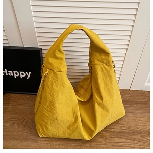 Detail of ginger yellow shoulder tote bag with zipper side and wrinkled nylon texture