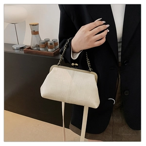 Close-up of white crocodile pattern doctor bag with vintage bronze metal frame and clasp