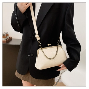 Detail of cream faux crocodile texture crossbody bag with gold chain strap and clasp
