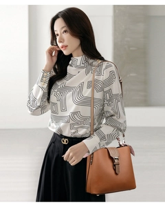 Detail of high neck printed blouse with geometric lines and elegant wide-leg trousers