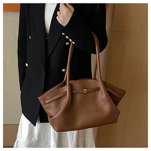 Details der braunen Vintage-Leder-Tote mit Seitenflügeln und goldener Metallschnalle