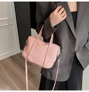 Detail view of pink lychee grain PU leather handbag with detachable shoulder strap and silver hardware