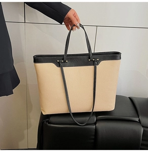 Detail of canvas tote bag with black leather stitching and white contrast seams