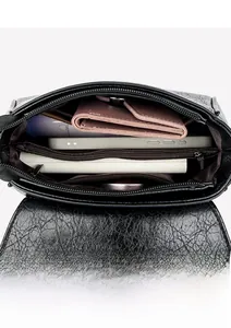 Vue de l'intérieur d'un sac en cuir noir avec compartiments multiples et poche zippée