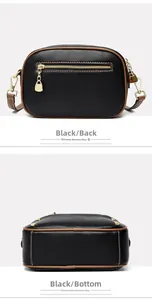 Detail view of the black pebbled leather texture and brown trim on the bag's back and bottom